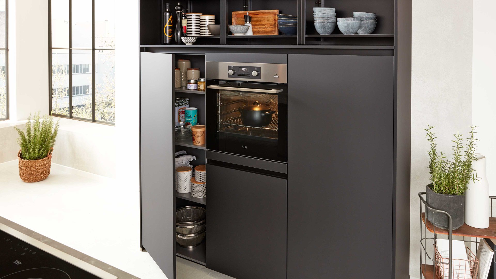 Einbauküche Interliving aus Holz in Schwarz Interliving Küche Serie 3100 mit AEG Einbaugeräten Schwarz & Quarzgrau – zweizeilig