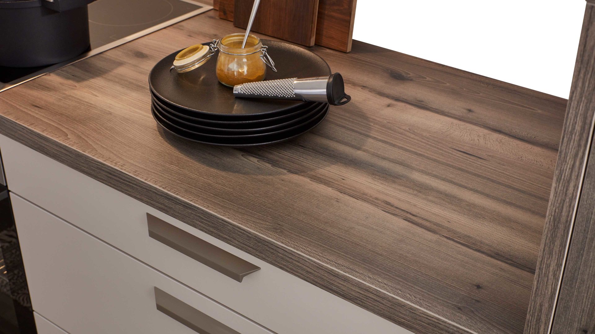 Einbauküche WERT KÜCHE® aus Holz in Beige WERT KÜCHE® Nora mit AEG Einbaugeräten Muschelweiß & Virginia Eiche – zweizeilig