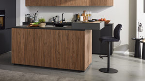 Einbauküche Interliving aus Holz in Schwarz Interliving Küche Serie 3076 mit Miele-Einbaugeräten Mattschwarz & Stripe Wood Choco - dreizeilig