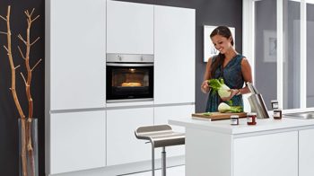 Einbauküche WERT KÜCHE® aus Holz in Hellbraun WERT KÜCHE® Nova mit Constructa und privileg Elektrogeräten Kristallgrau & Trüffelbraun - zweizeilig