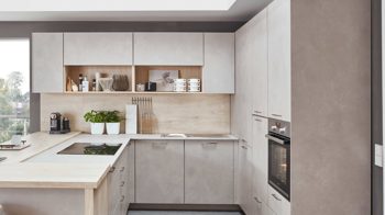 Einbauküche Nobilia® aus Holz in Holzfarben Hell nobilia® Einbauküche Riva mit JUNKER Elektrogeräten und Esstheke Beton Sand & Eiche Montreal - Stellfläche ca. 304 x 319 cm