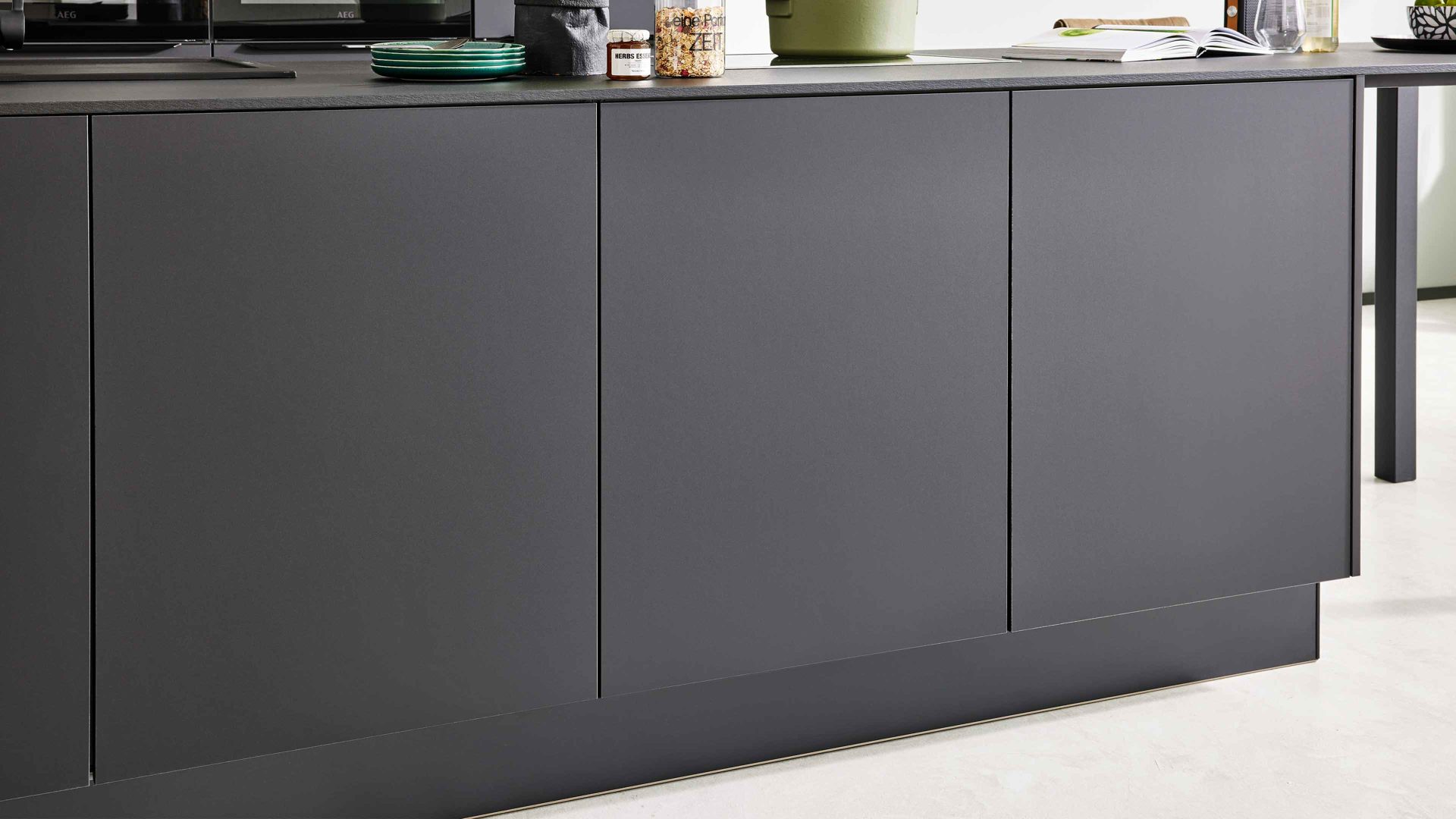 Einbauküche Interliving aus Holz in Schwarz Interliving Küche Serie 3057 mit AEG Einbaugeräten Mattschwarz – zweizeilig