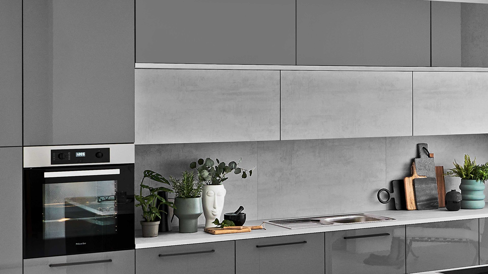 Einbauküche Nolte® küchen aus Holz in Grau nolte® Einbauküche Lux mit Miele Einbaugeräten Quarzgrau & weißer Beton – zweizeilig