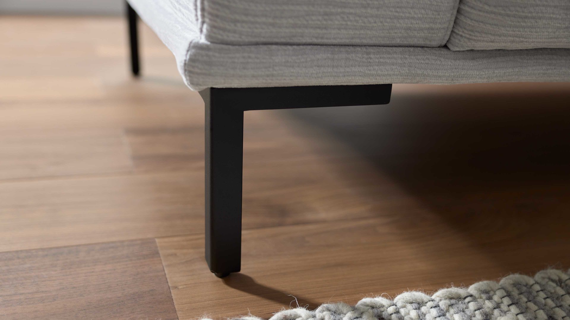 Polsterhocker Interliving aus Stoff in Hellgrau Interliving Sofa Serie 4255 – Polsterhocker silberfarbener Bezug Mara 9 & schwarze Metallfüße 4.26 - ca. 65 x 95 cm