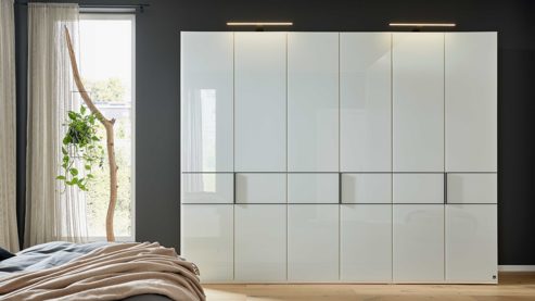 Möbelbeleuchtung Interliving aus Holz in Weiß Interliving Schlafzimmer Serie 1033 – Kleiderschrank 605 mit Beleuchtung weißes Glas & Holz – sechs Türen, Breite ca. 300 cm
